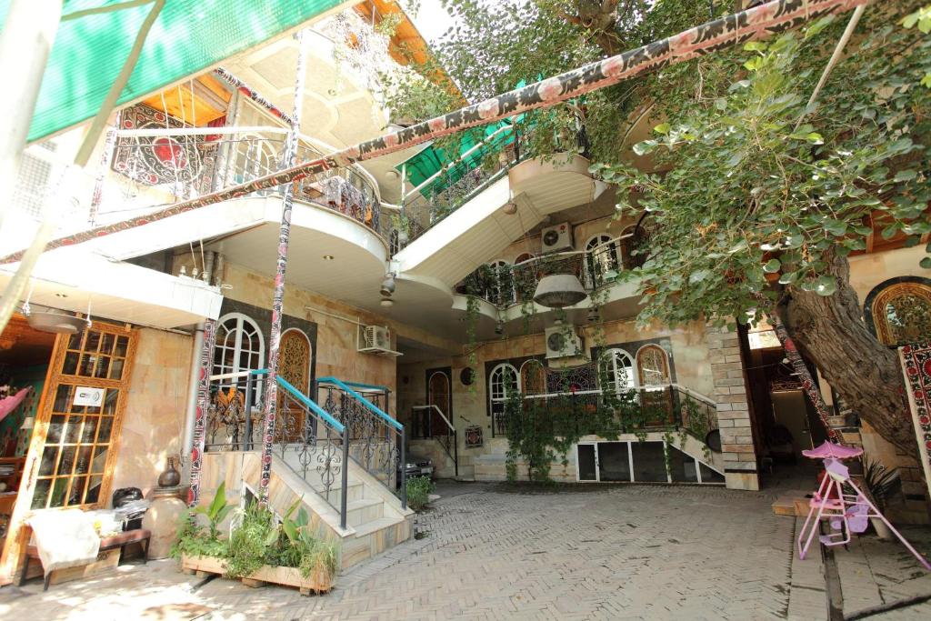 a building with a lot of windows and plants at Furkat Guest House in Samarkand