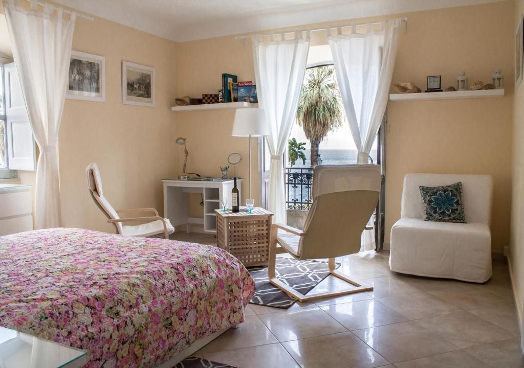 ミラッツォにあるCasa Marinaのベッドルーム1室(ベッド1台、椅子、窓付)