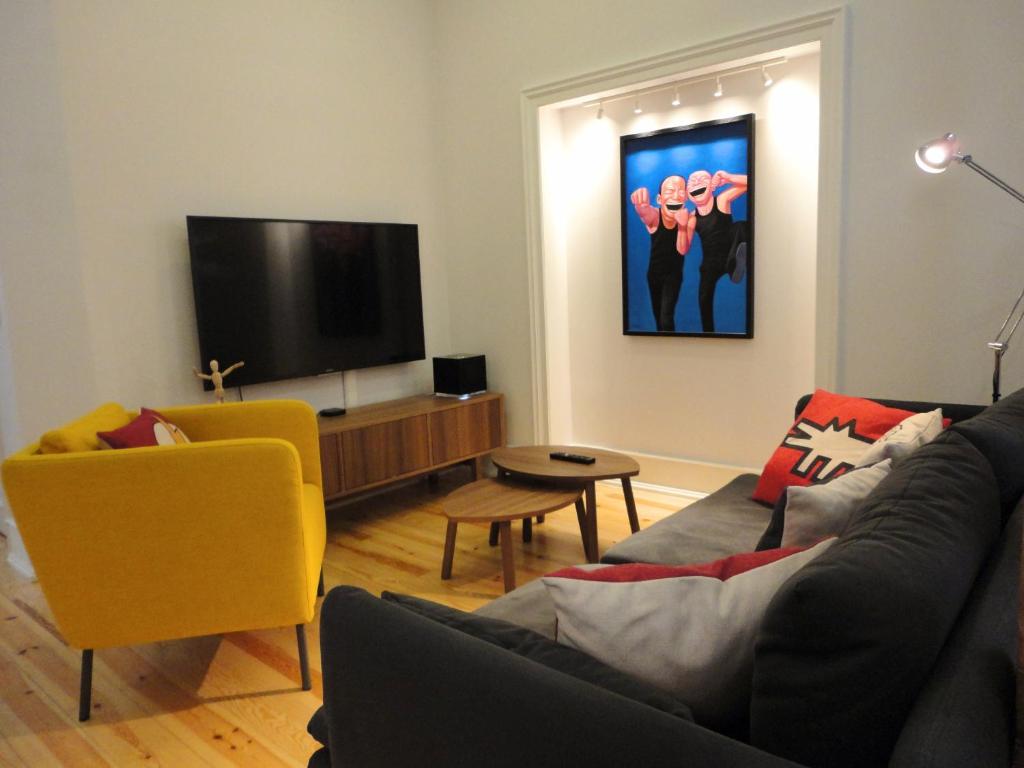 ein Wohnzimmer mit einem Sofa und einem Flachbild-TV in der Unterkunft Lisbon Center Modern Art Apartment in Lissabon