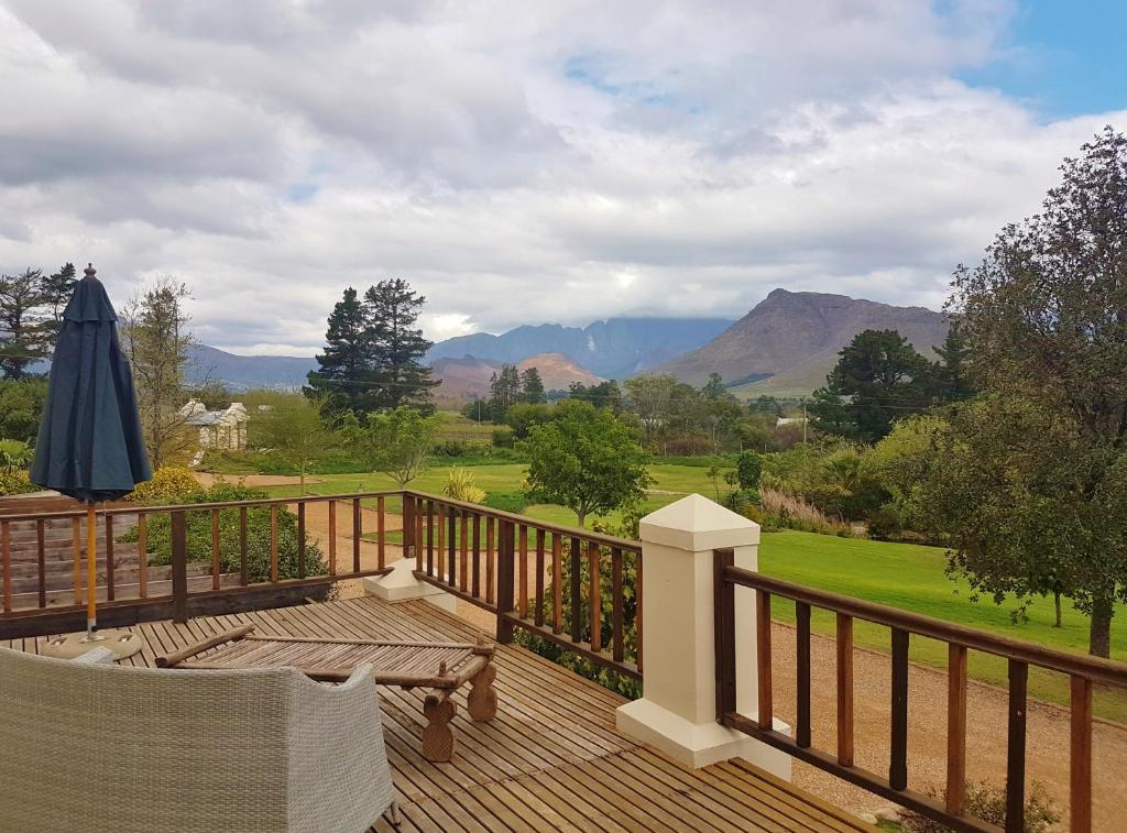 a wooden deck with a table and an umbrella on it at Val d'Or Estate in Franschhoek