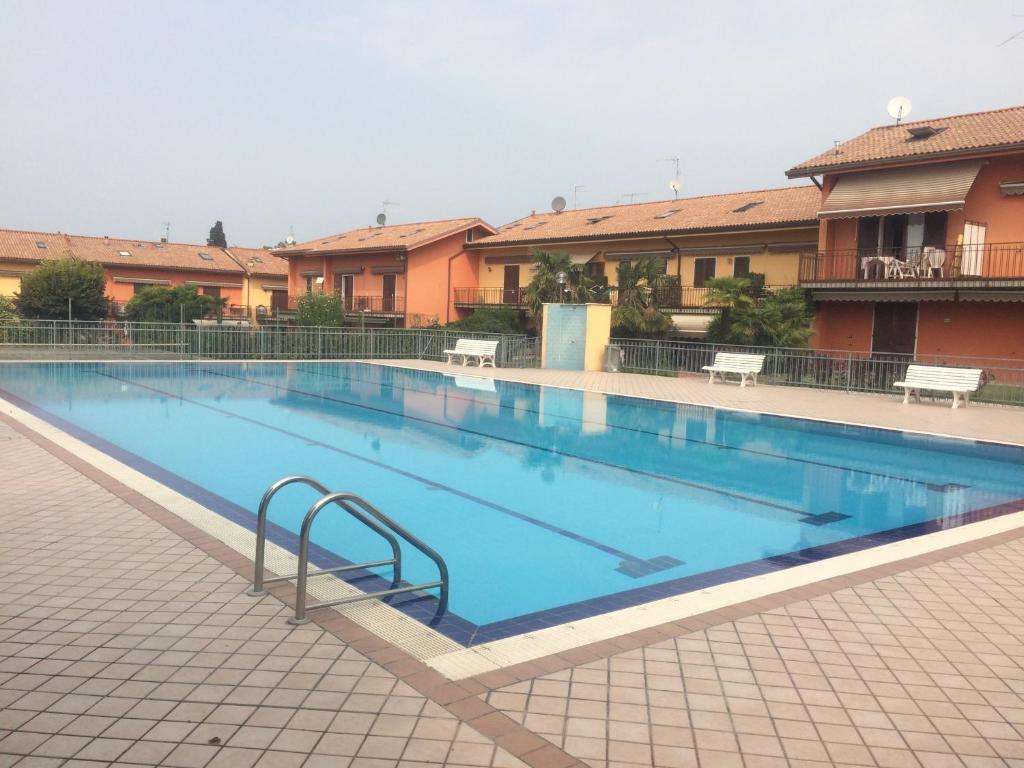 a large swimming pool with blue water in a building at Appartamento dei Salici in Lazise