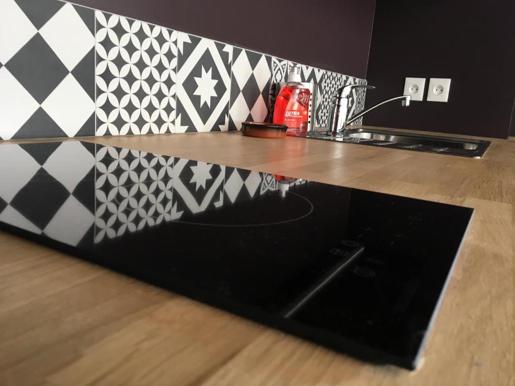 a kitchen counter with a black counter top with black and white tiles at Quintessens in Marseille