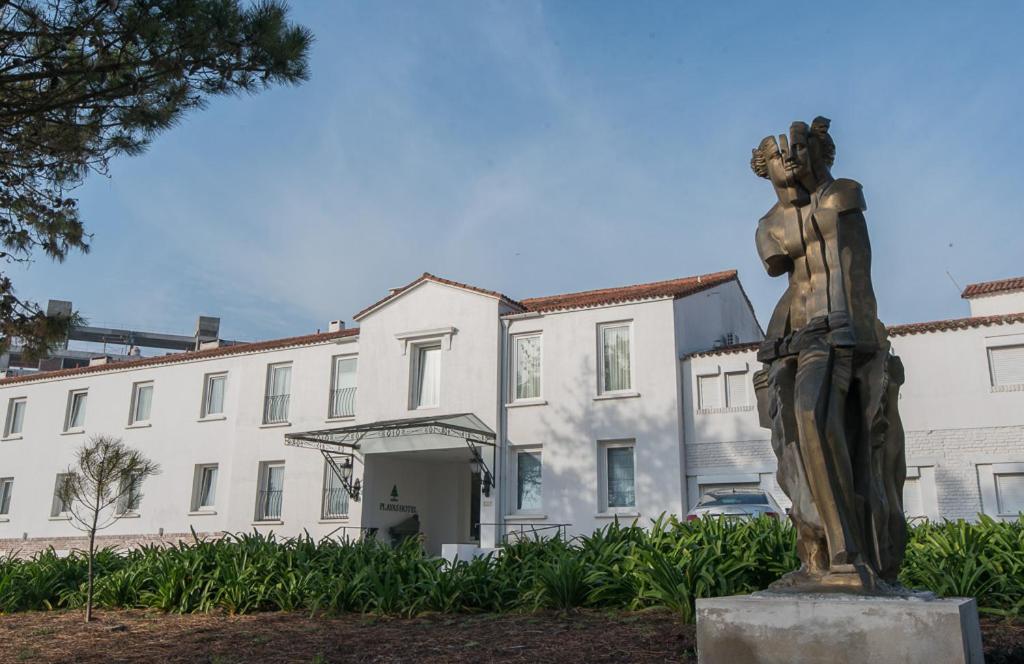 una estatua de una mujer frente a un edificio en Playas Art Hotel en Pinamar