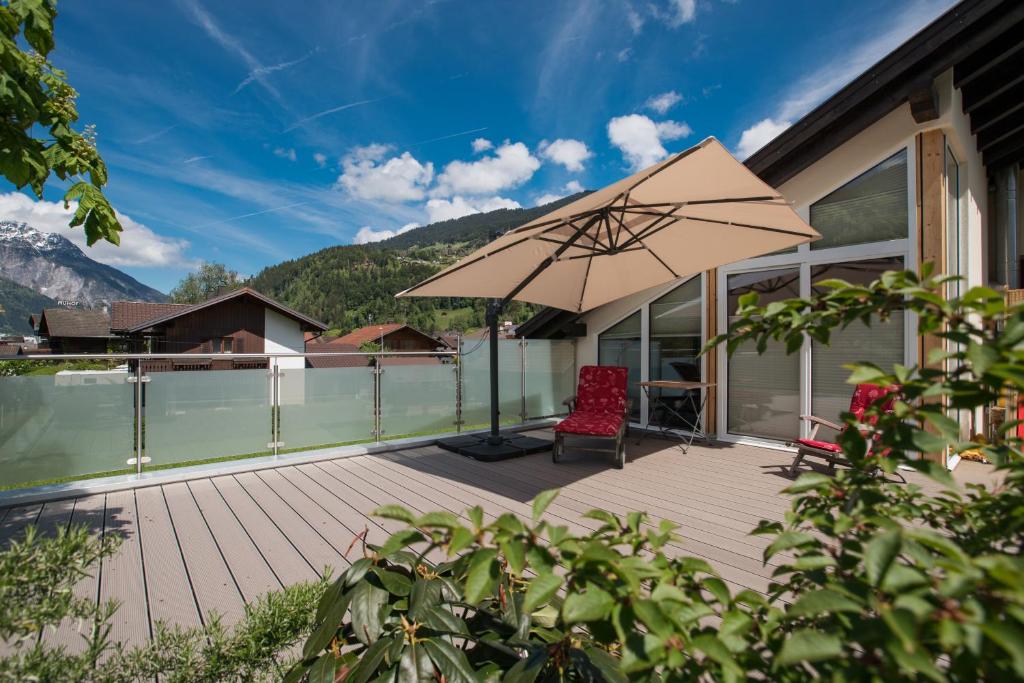 a patio with a chair and an umbrella at Panoramablick in Schruns-Tschagguns