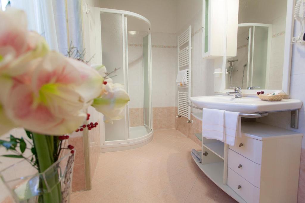 uma casa de banho branca com um lavatório e um chuveiro em Hotel Principe em Salsomaggiore Terme
