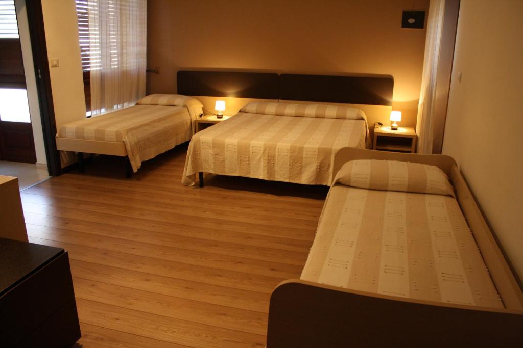 a hotel room with two beds and two tables at B&B 5 Sensi in Belpasso