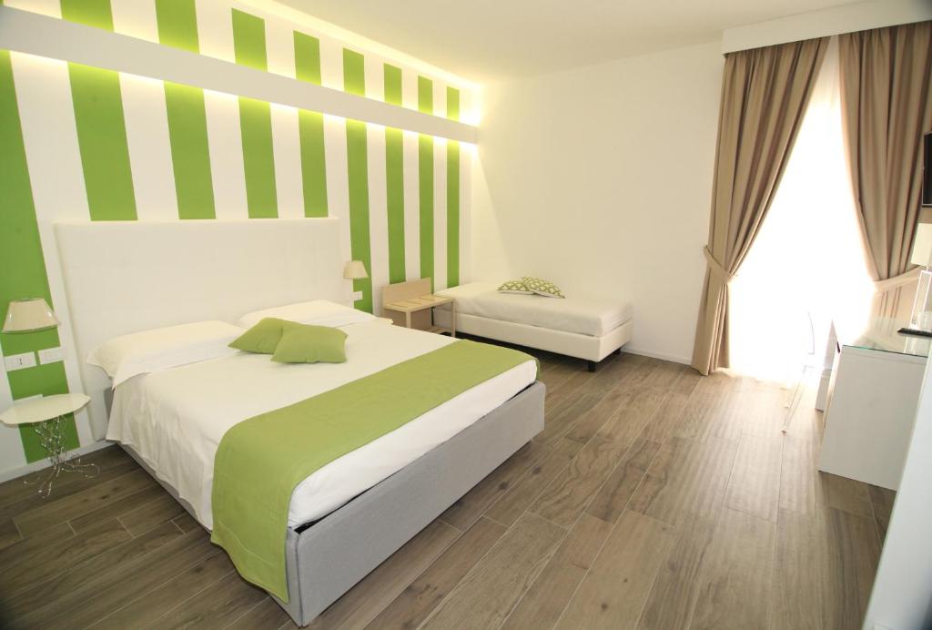 レッジョ・ディ・カラブリアにあるDomus Novaの緑と白のストライプのベッド1台が備わるベッドルーム1室