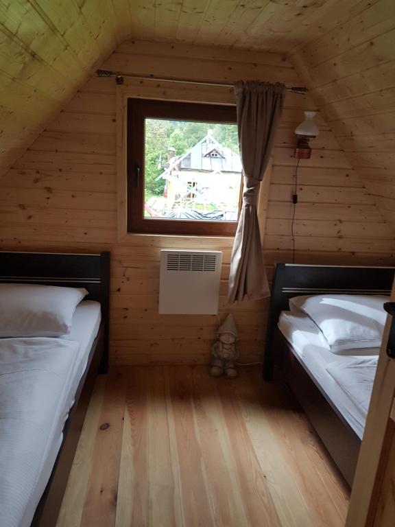 カルパチにあるDomek pod śnieżką 1の木造キャビン内のベッドルーム1室(ベッド2台付)