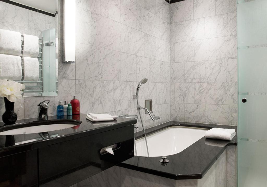a bathroom with a bath tub and a sink at Grand Hôtel Stockholm in Stockholm