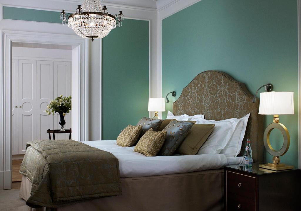 a bedroom with a large bed with blue walls and a chandelier at Grand Hôtel Stockholm in Stockholm
