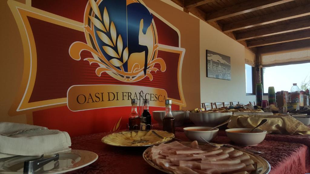 - une table avec des assiettes de nourriture et des bouteilles de vin dans l'établissement Oasi Di Francesca, à Gerbini