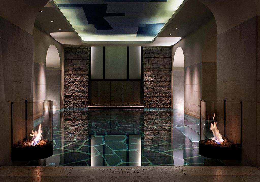 a swimming pool with two fireplaces in a building at Grand Hôtel Stockholm in Stockholm