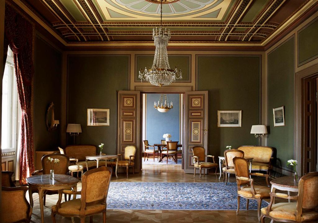 a room with tables and chairs and a chandelier at Grand Hôtel Stockholm in Stockholm