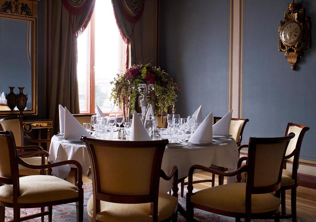 a dining room with a white table with chairs and a tablestration at Grand Hôtel Stockholm in Stockholm