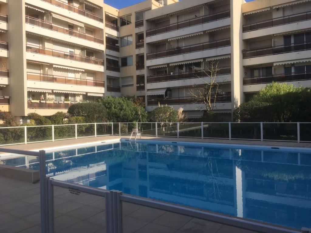 une piscine en face d'un bâtiment dans l'établissement Meublés de Tourisme Beaulieu, à Beaulieu-sur-Mer