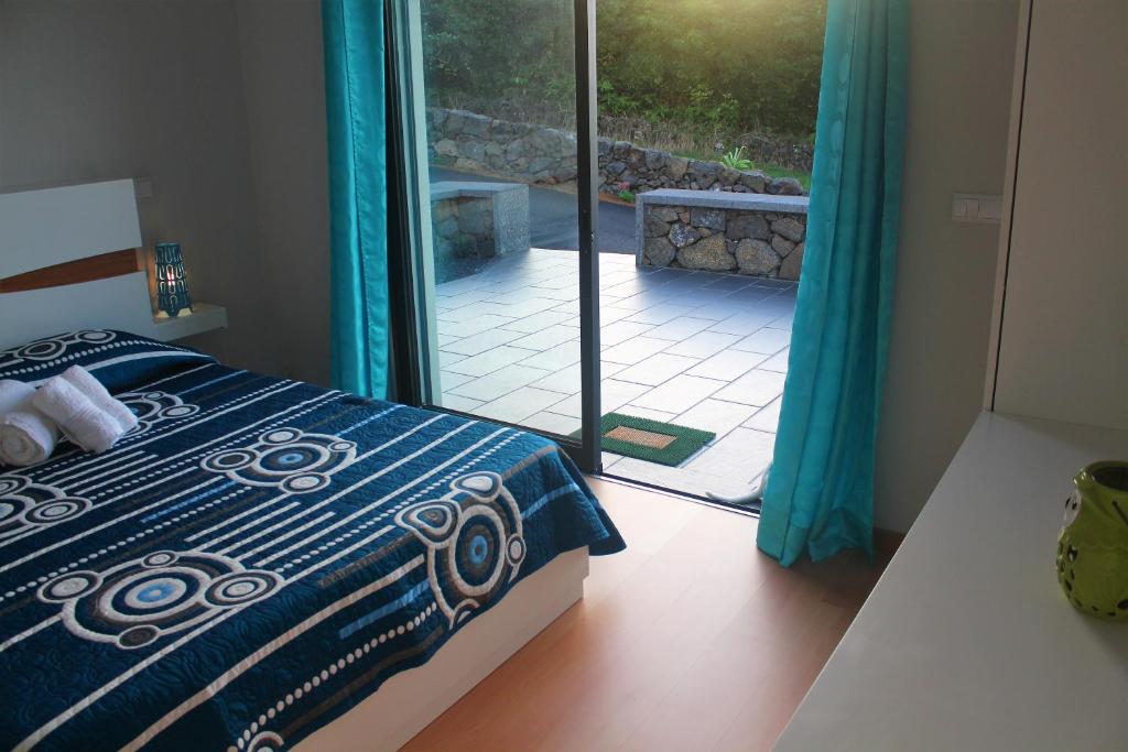 a bedroom with a bed and a door to a patio at Vila Paim in Santo Antonio