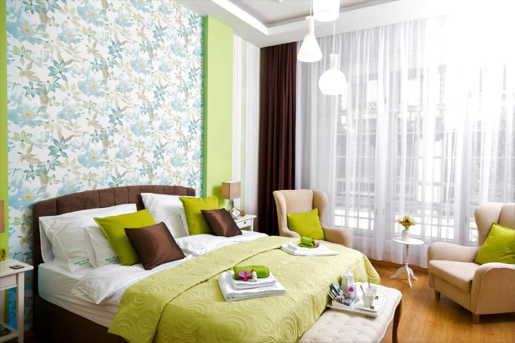 a bedroom with a bed and a couch and chairs at Makes You Happy Budapest in Budapest