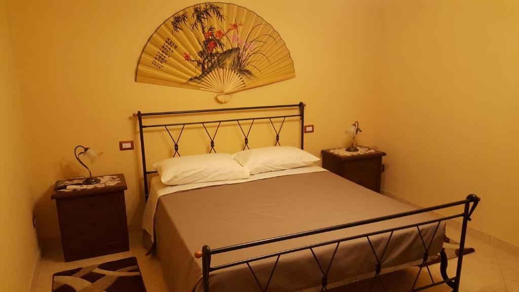 a bedroom with a bed with a fan on the wall at Guest house le grazie in Orte