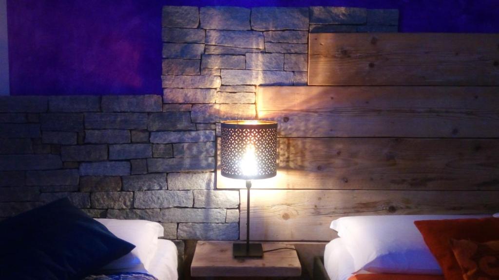una lámpara en una mesa en un dormitorio con una pared de ladrillo en Marconi Rooms and Apartments, en Verona