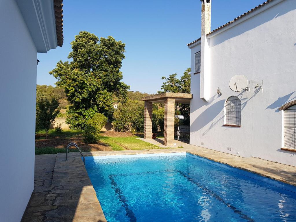 una piscina di fronte a un edificio bianco con una casa di Villa Fructus a Vejer de la Frontera
