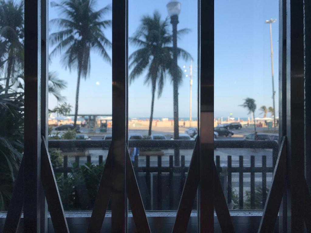 ventana con vistas a la playa y a las palmeras en Atlantica Lofts, en Río de Janeiro