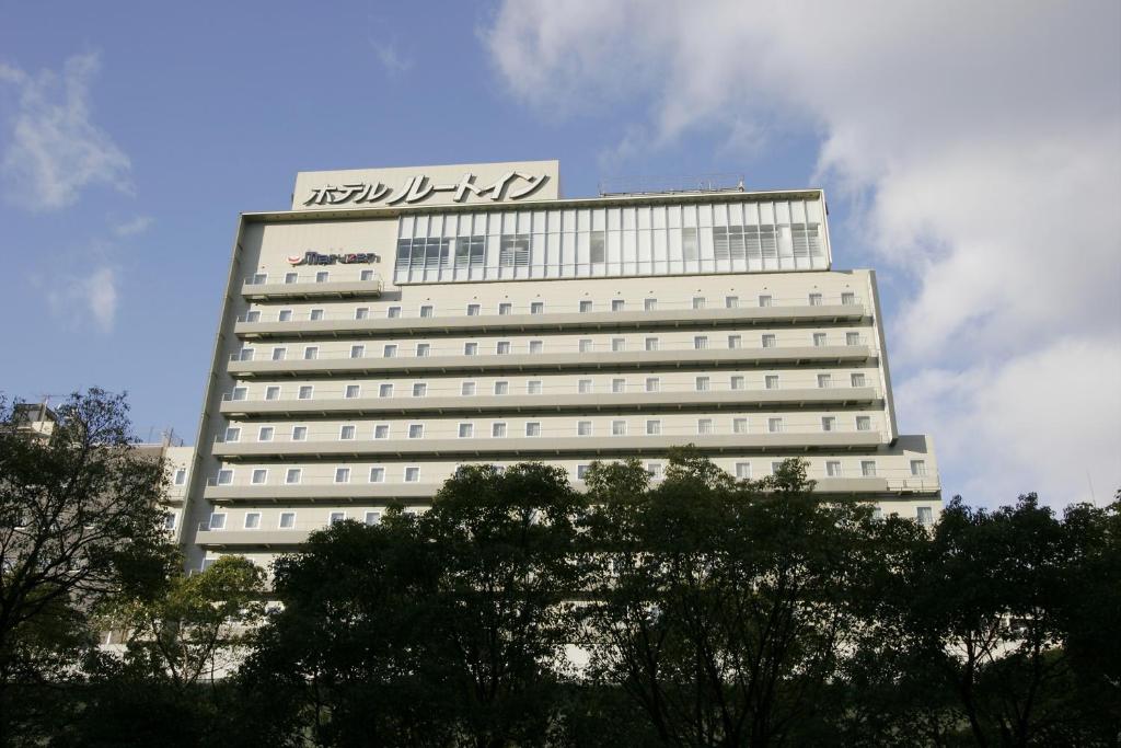 um grande edifício branco com um cartaz em Hotel Route-Inn Osaka Honmachi em Osaka