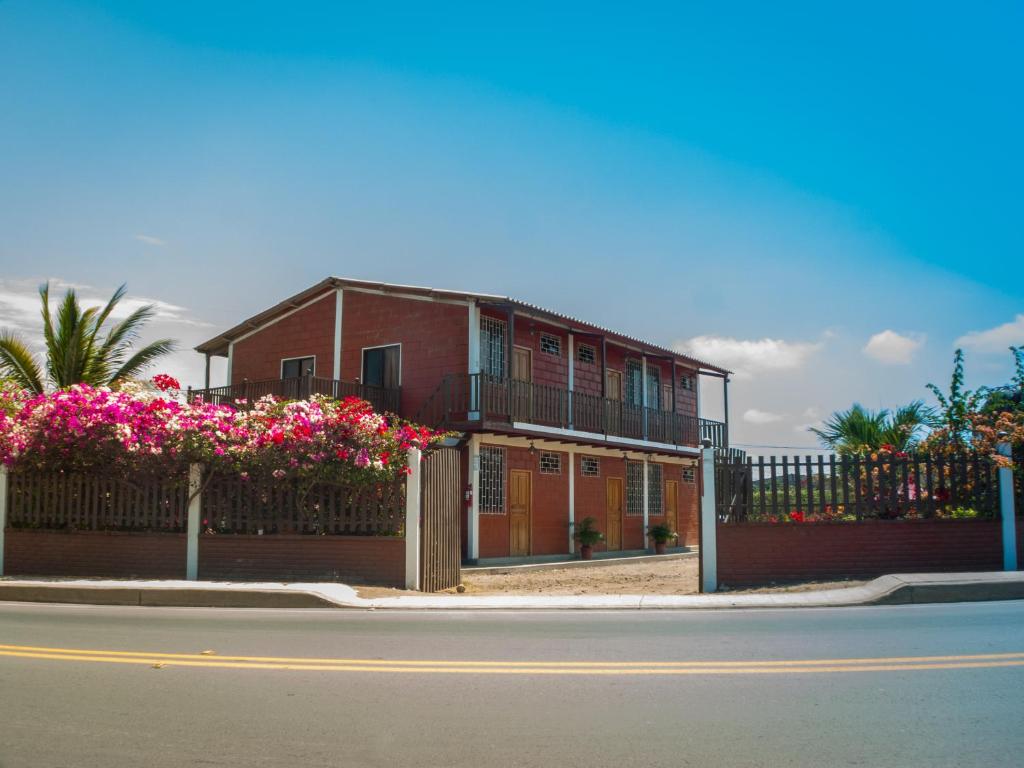 uma casa com flores em frente a uma cerca em Sol de Playa em Playas