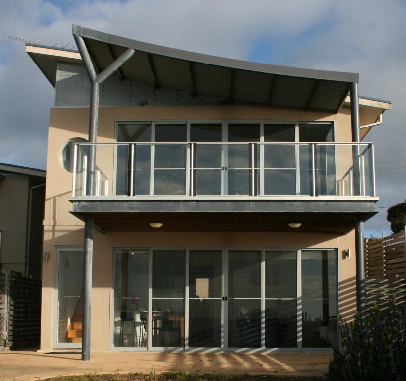 uma casa com uma varanda em cima em Penneshaw Oceanview Apartments em Penneshaw