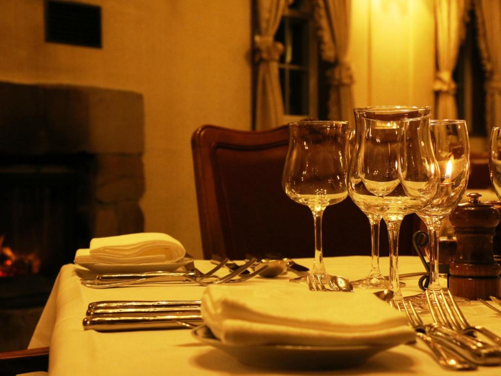 un tavolo con bicchieri da vino su una tovaglia bianca di Pension Raisin a Kusatsu