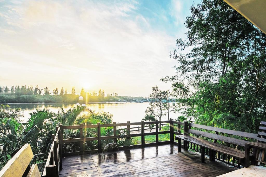 una terraza de madera con un banco y vistas al lago en Krabi City Seaview Hotel en Krabi