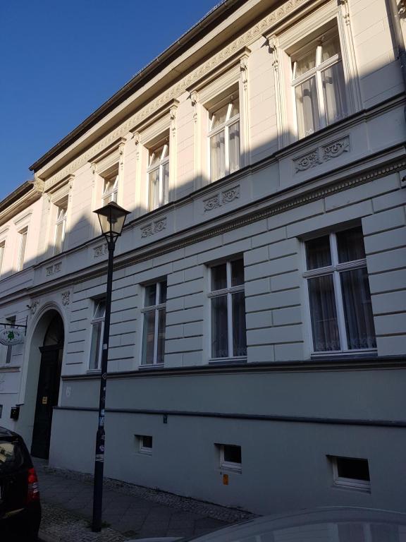 a white building with a street light in front of it at Pension zum Birnbaum in Brandenburg an der Havel