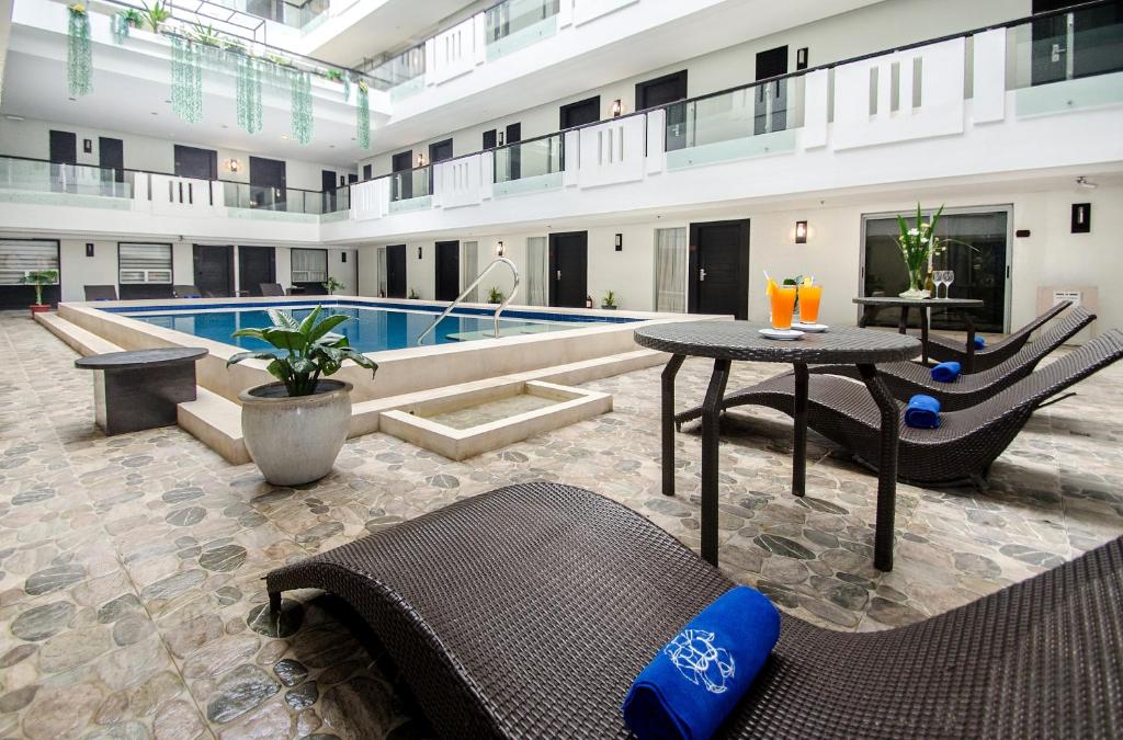 ein großes Gebäude mit einem Pool und einem Tisch mit Stühlen in der Unterkunft The Muse Hotel in Boracay