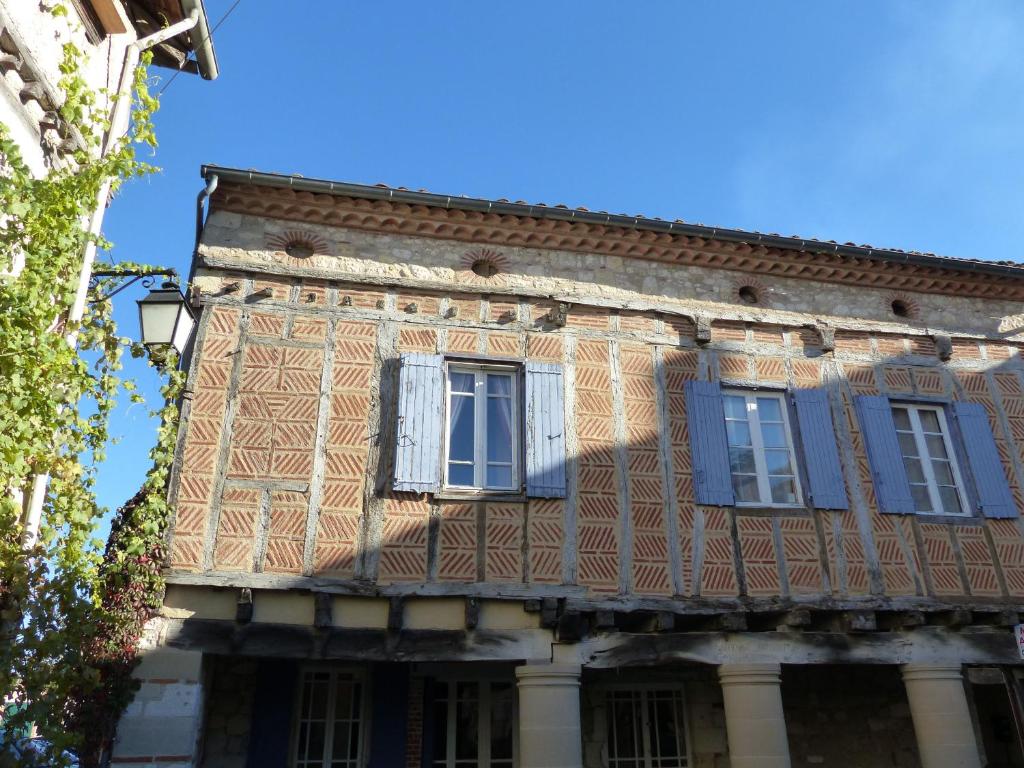 ein altes Gebäude mit Fenstern und blauen Fensterläden in der Unterkunft Plume Et Pinceau in Montdragon