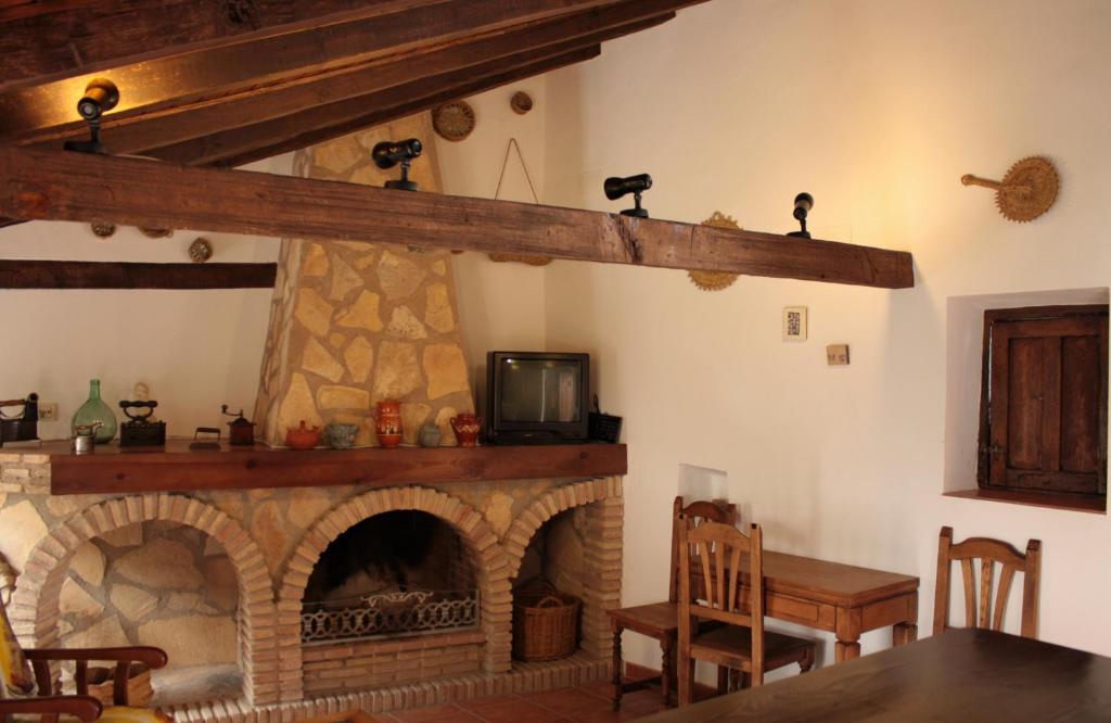 sala de estar con chimenea y TV en Casa Ribera de Cazorla, en Cazorla