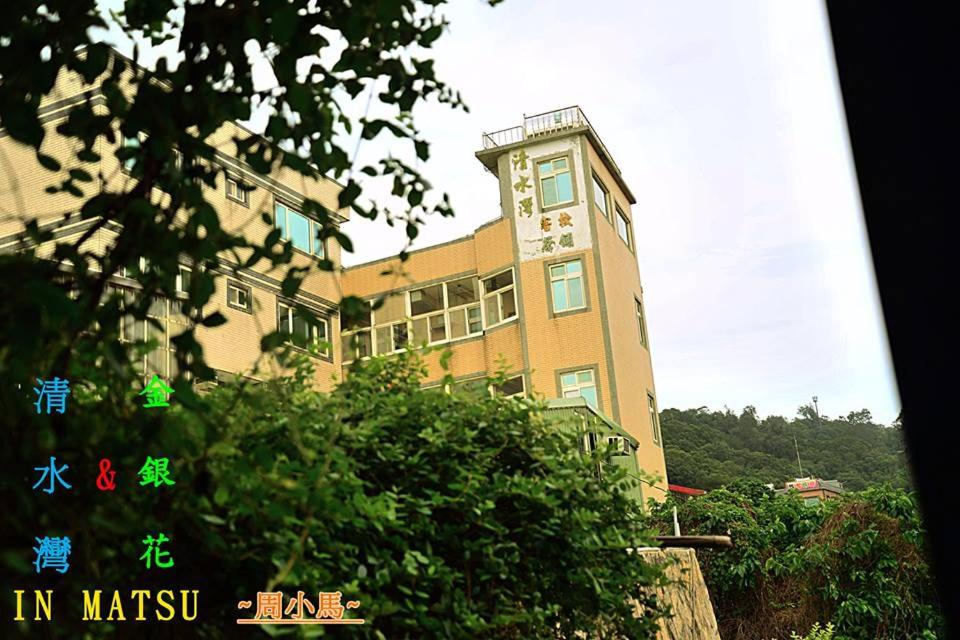 een gebouw met een klok aan de zijkant bij Clear Water Bay Homestay in Nangan
