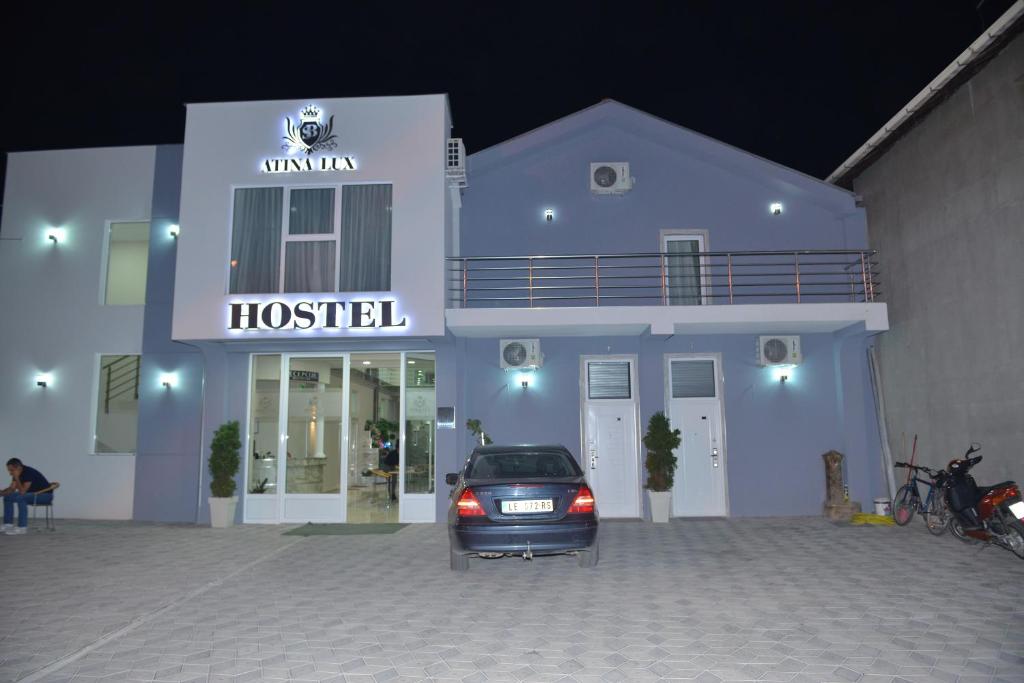 un coche aparcado delante de un hotel por la noche en Atina Lux Hostel en Leskovac