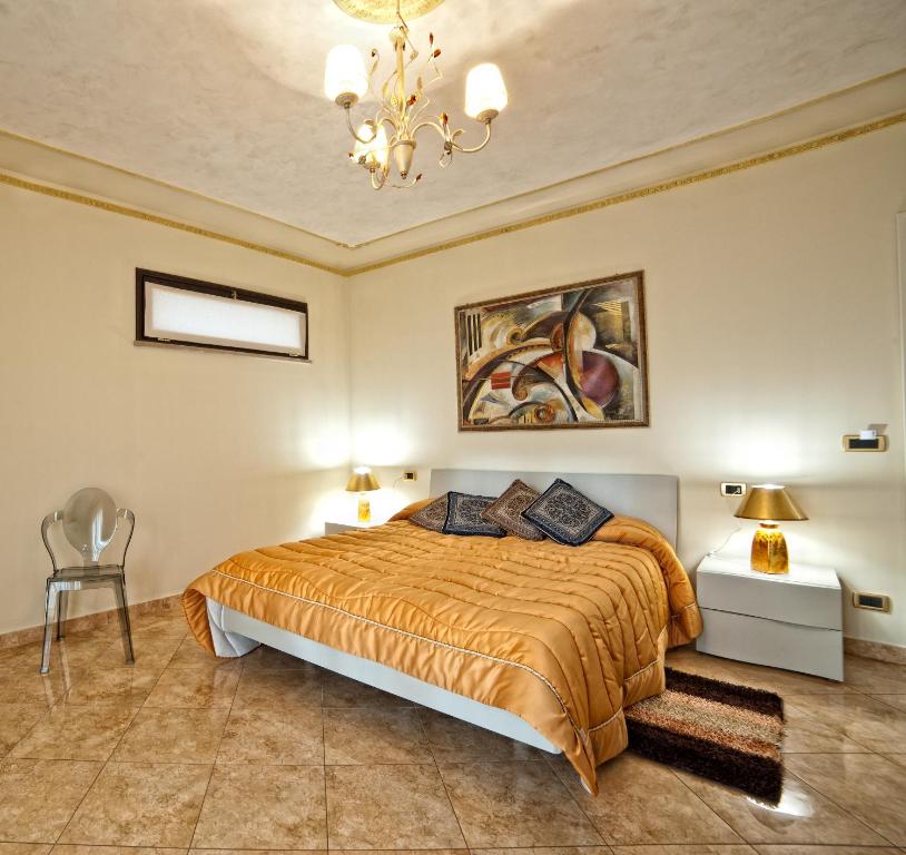 a bedroom with a bed and a chandelier at Airport House B&B in Reggio Calabria