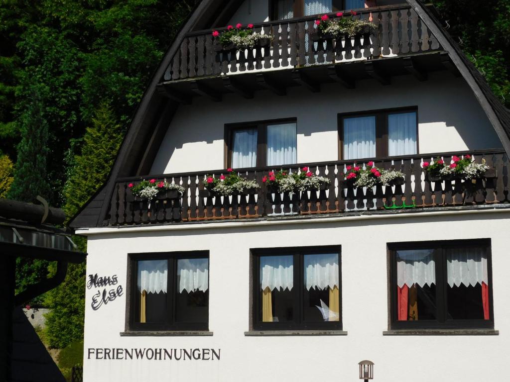 una casa blanca con flores en las ventanas en Ferienwohnungen Haus Else, en Willingen