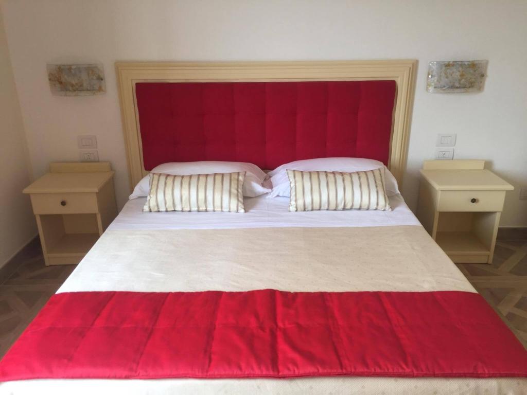 a bedroom with a large bed with a red headboard at Il Salice in Civitella del Tronto