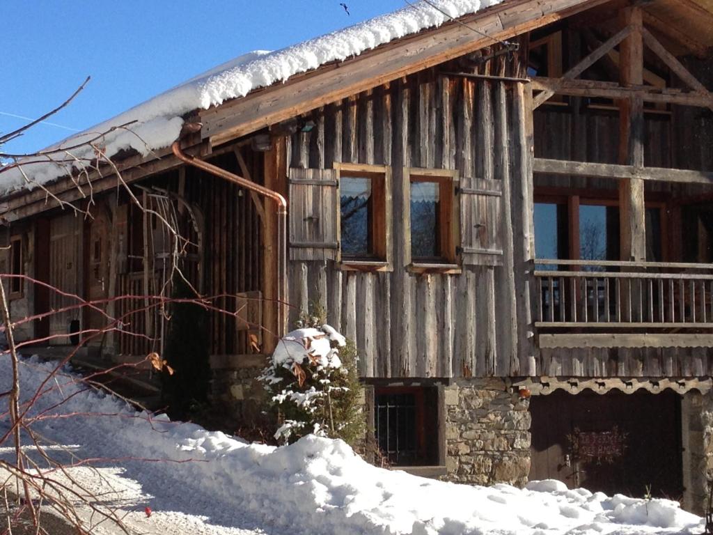 レ・ジェにあるChalet Ferme des Amisの雪の積もった古いログキャビン