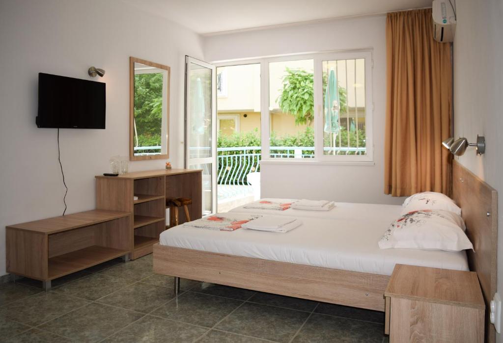ラブダにあるStella di Mare Guest Houseのベッドルーム(ベッド1台、テレビ、窓付)