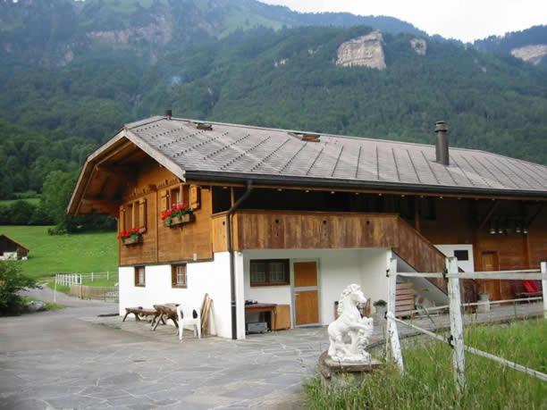 ein Haus mit einem Tisch und Stühlen davor in der Unterkunft Eichhof Brienzwiler Berner Oberland in Brienzwiler