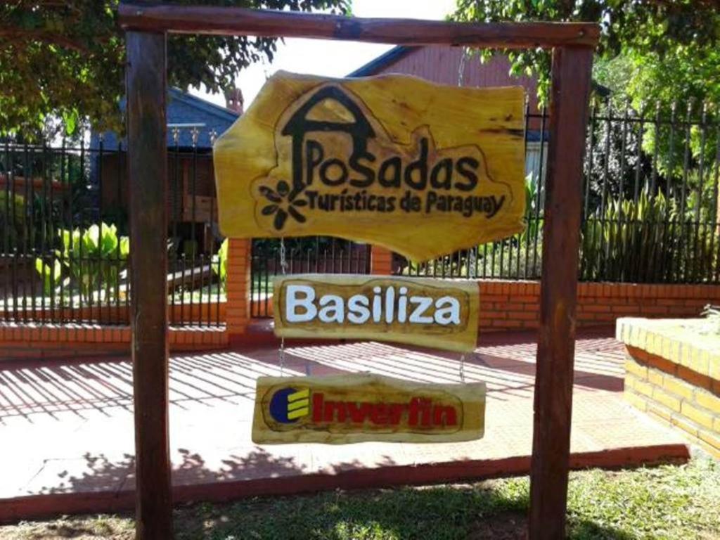 um sinal para um restaurante barillailla em frente a uma cerca em Posada Basiliza, Encarnación PY em Encarnación