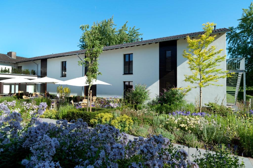 einen Garten mit Blumen vor einem Gebäude in der Unterkunft Landhaus Beckmann in Kalkar