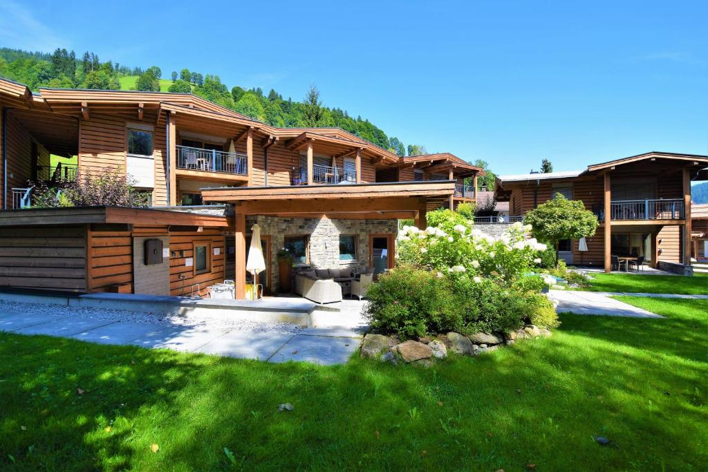 duży dom z zielonym trawnikiem przed nim w obiekcie Resort Tirol am Wildenbach w mieście Niederau