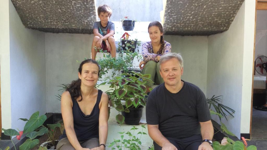 a man and two women sitting on a porch with a child at City- in Safari Resort in Udawalawe