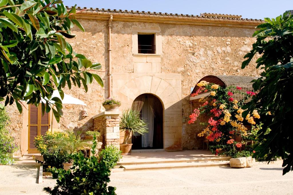 a stone building with flowers in front of it at Sa Carrotja - Adults Only in Ses Salines