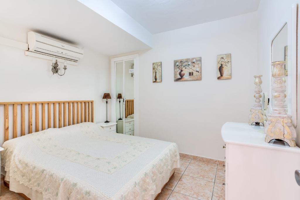 ベナルマデナにあるCorinto Apartmentの白いベッドルーム(ベッド1台、鏡付)