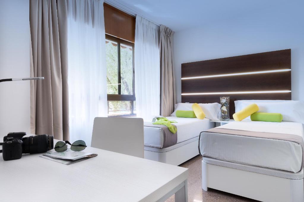 un soggiorno con 2 letti e un divano di Roisa Hostal Boutique a Madrid
