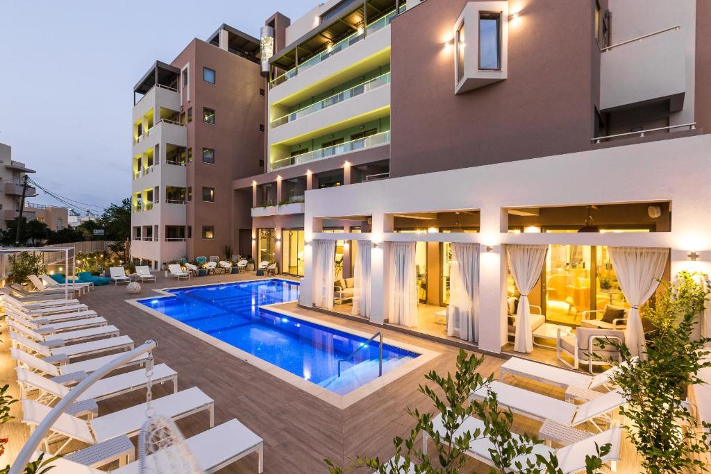 an image of a building with a swimming pool and lounge chairs at Menta City Boutique Hotel in Rethymno Town